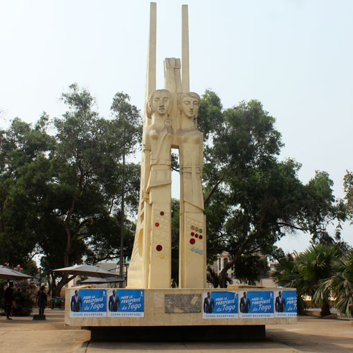 Faure Gnassingbé und Wahlplakate auf dem Monument in Baguida, Togo